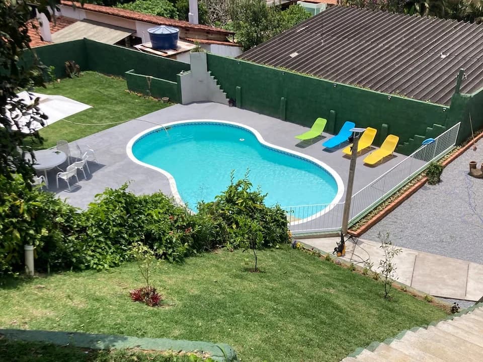 O terreno da Tinog Lofts visto de cima: a piscina, as espreguiçadeiras e o gramado em degraus